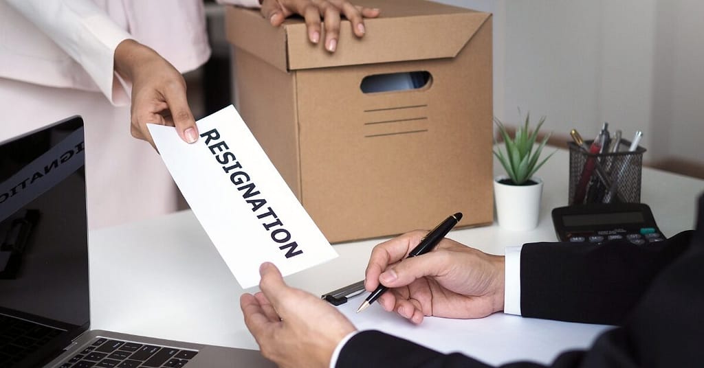 Empty office desk with resignation letter symbolizing high employee turnover