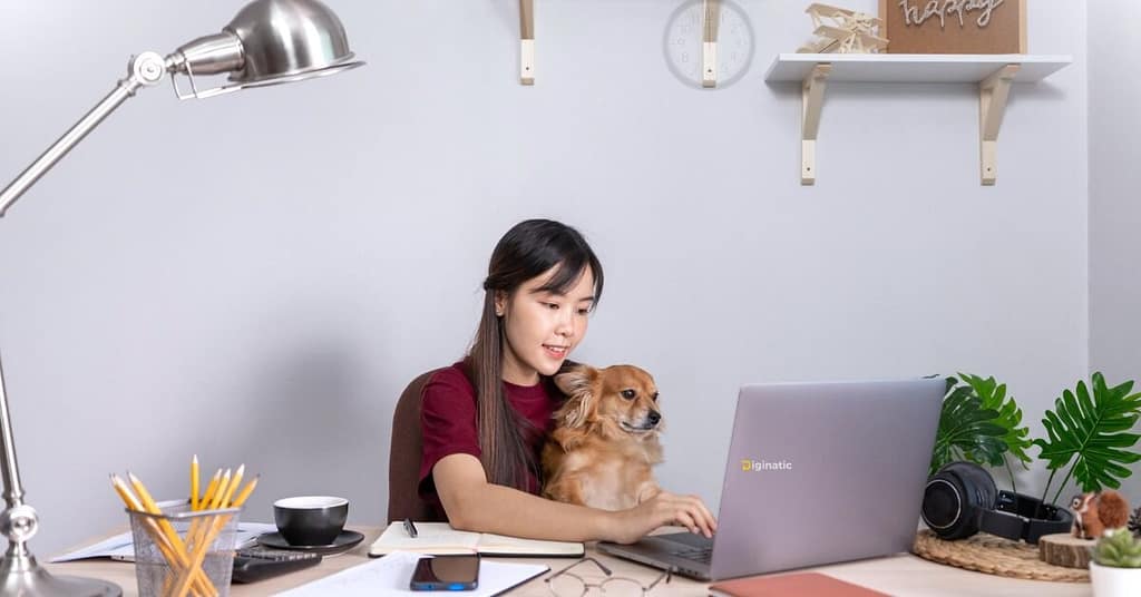 Cute pet dog beside Filipino remote worker’s laptop